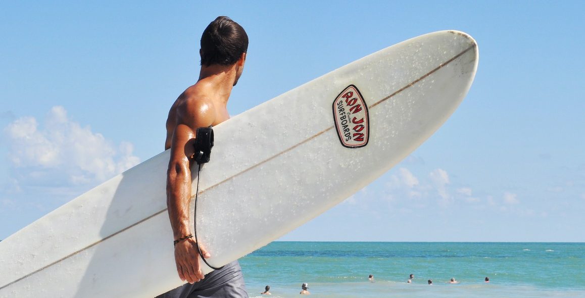 Male carrying surf board 